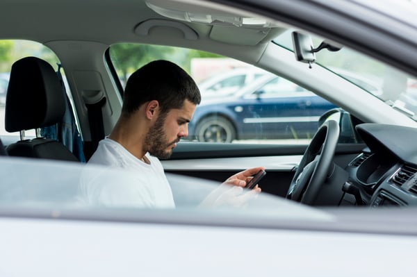 male-using-smartphone-while-sitting-car